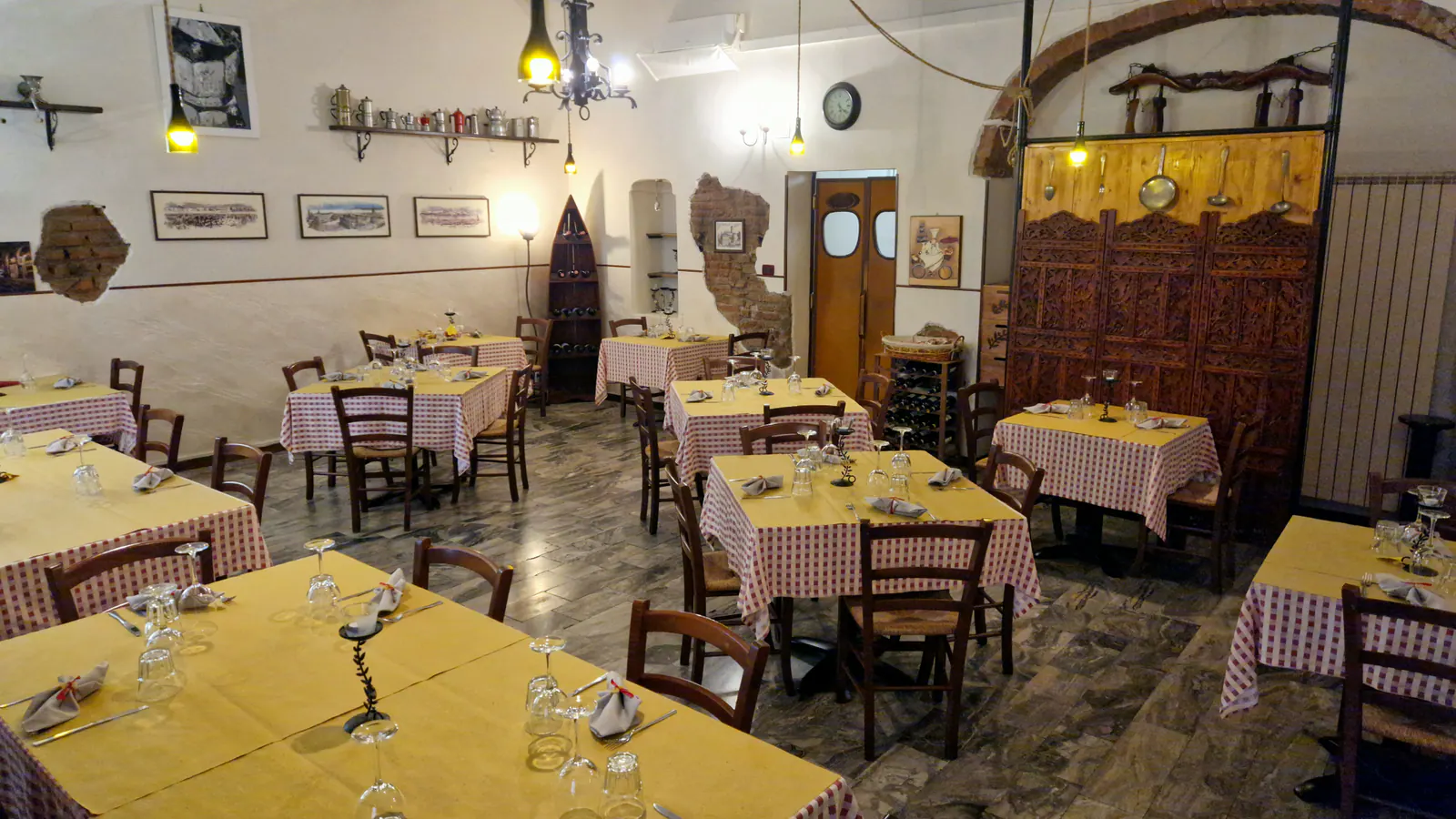 La sala di Aldente: tavoli apparecchiati con tovaglie a quadri bianche e rosse